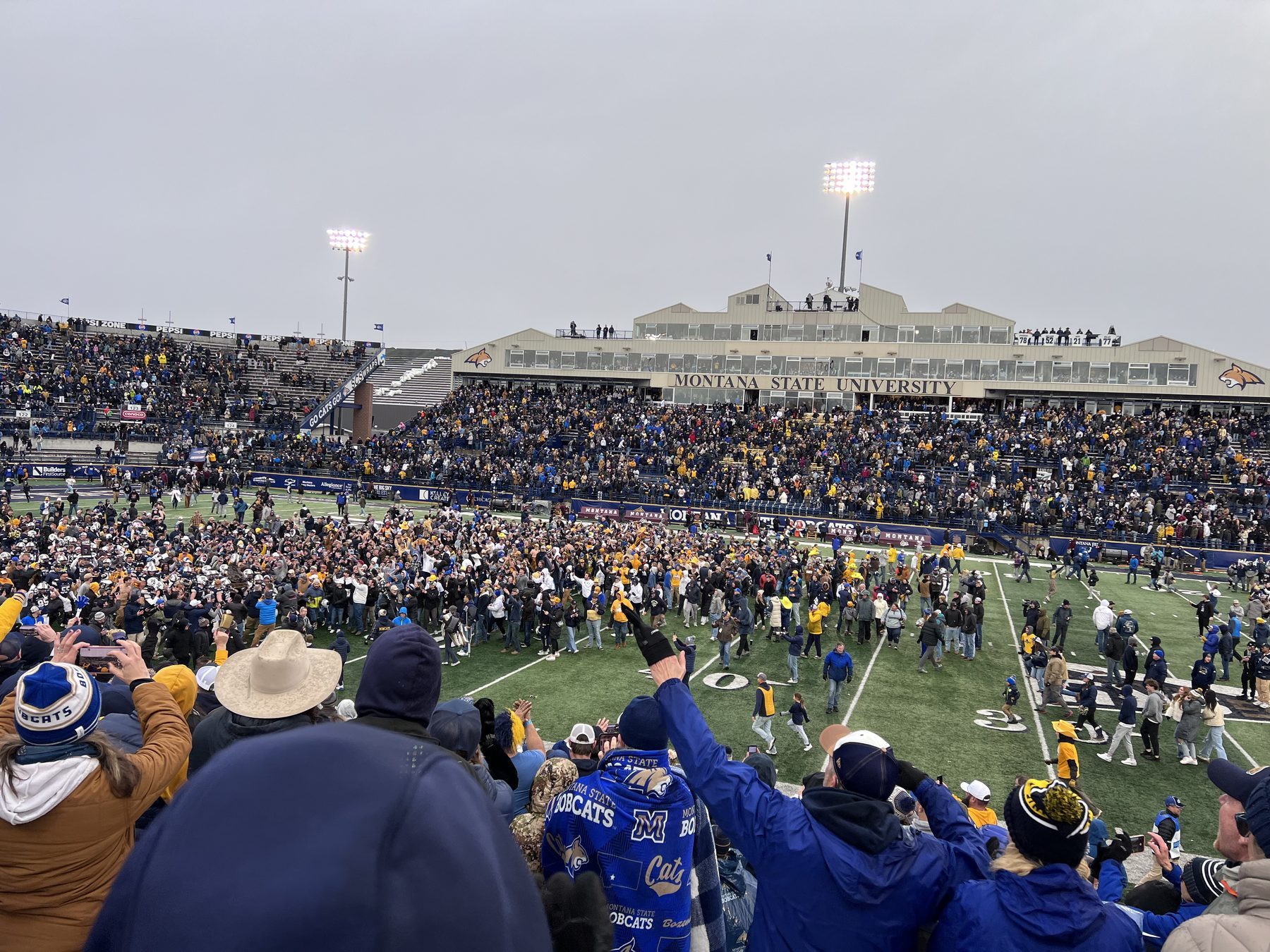 Montana State fans storm the field at Bobcat Stadium in Bozeman under the Montana State University press box